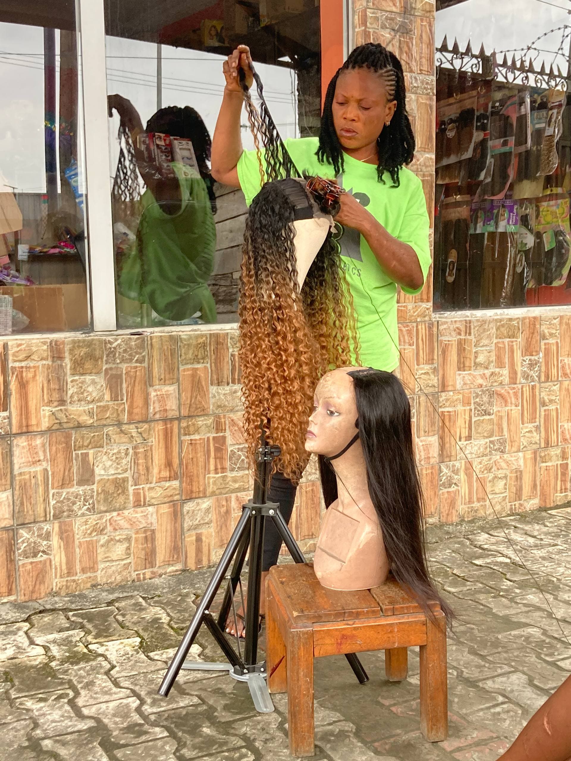 A participant working on a hair styling mannequin